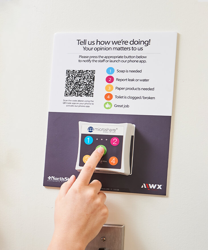 An AIWX connect device mounted on a wall for obtaining feedback on employee performance and facilities statuses.
